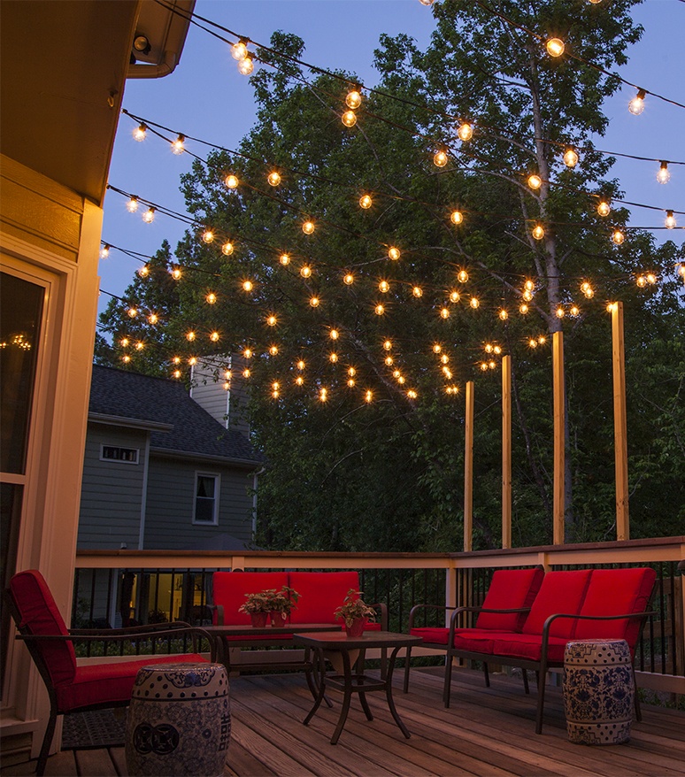 night image of string lights hanging over a home deck or patio with outdoor furniture below